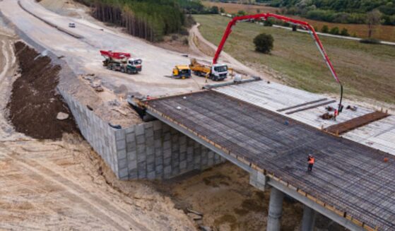 A bridge is being built linking one hill to another.