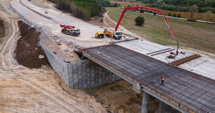A bridge is being built linking one hill to another.