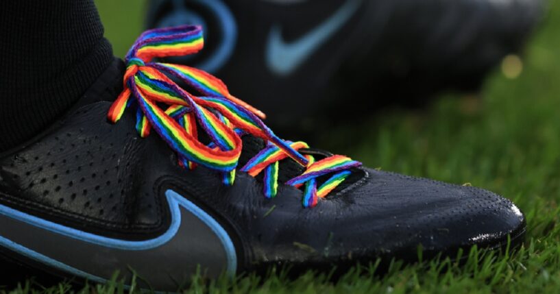 A pair of Nike cleats are adorned with rainbow laces in a file photo from a Premier League soccer match in London in November 2021.