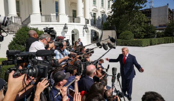 President Donald Trump deals with a horde of reporters outside the White House Oct. 1.
